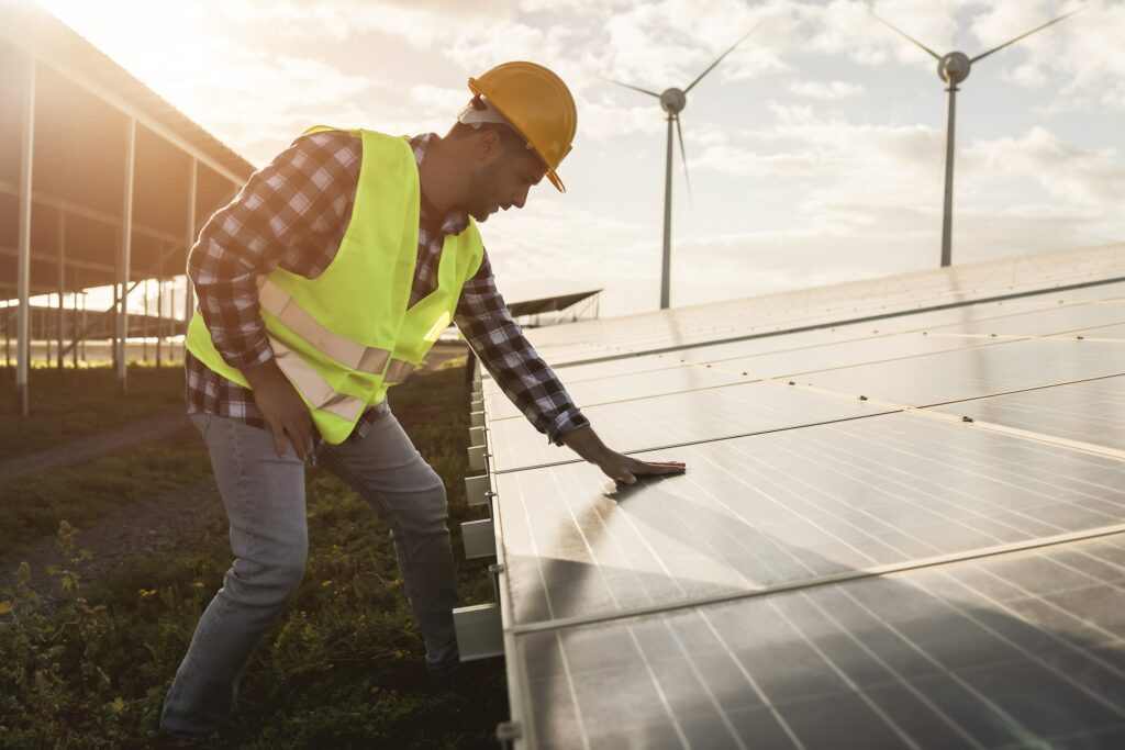 Young man working at renewable energy farm - Eco and environment concept - Focus on hand